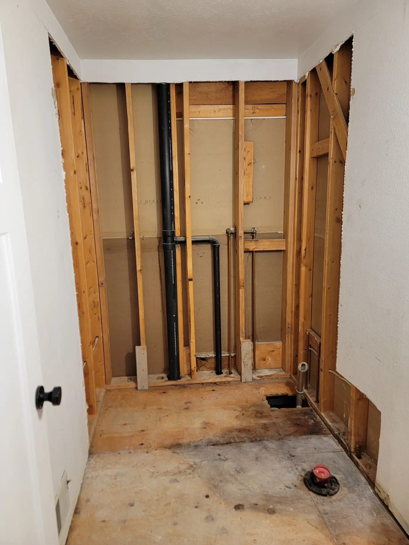 Down to the framing — old plumbing exposed