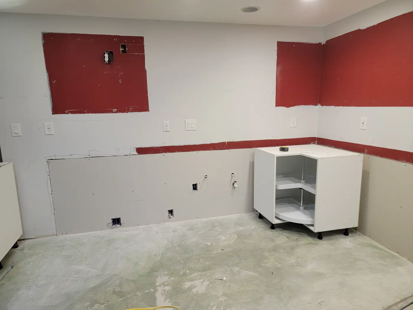 The first base cabinet against the old red wall