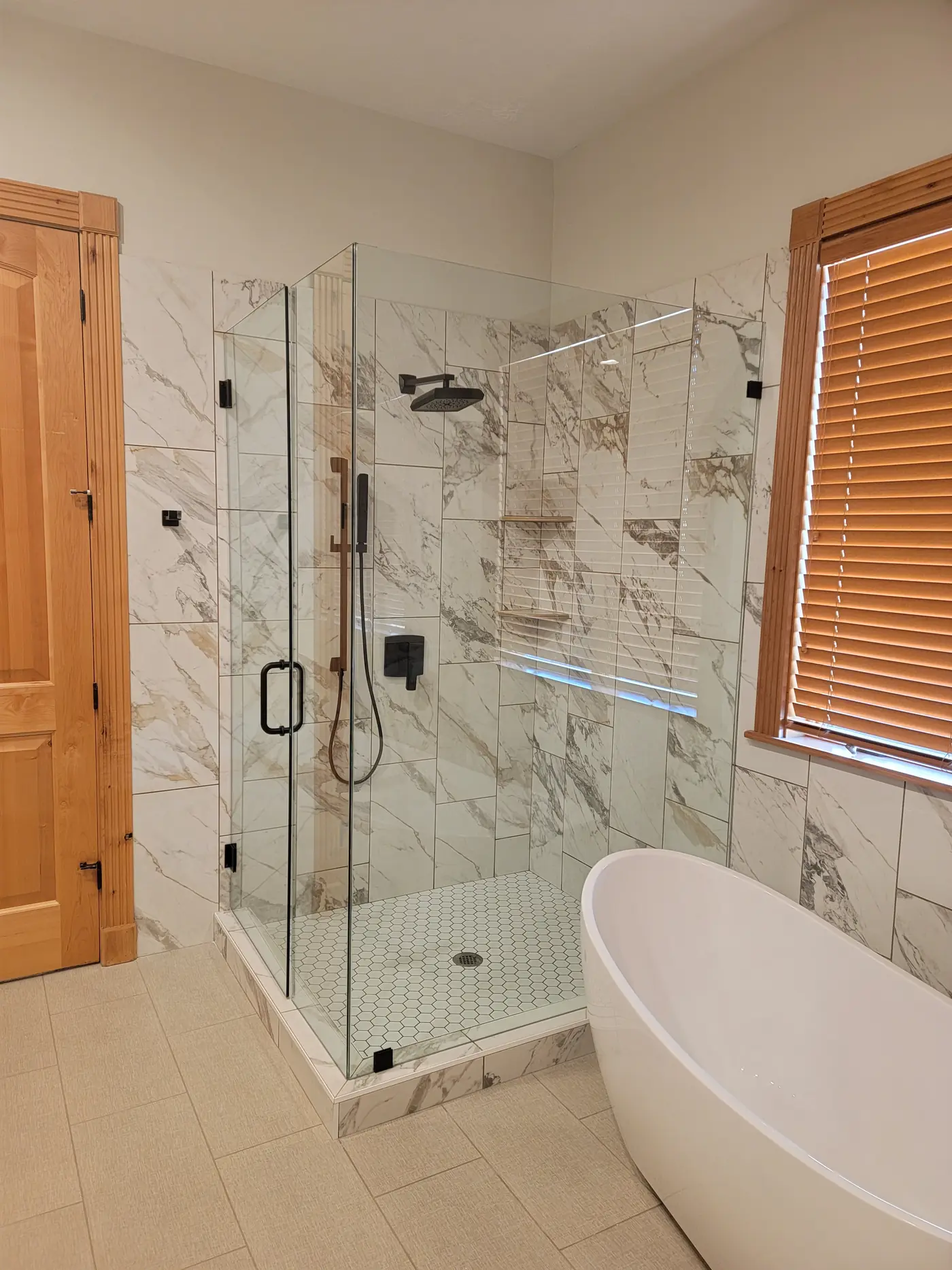 Finished frameless glass shower in marble-look tile