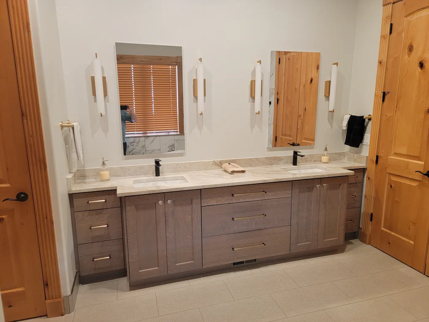 Finished primary bath with a double vanity and marble-look tile