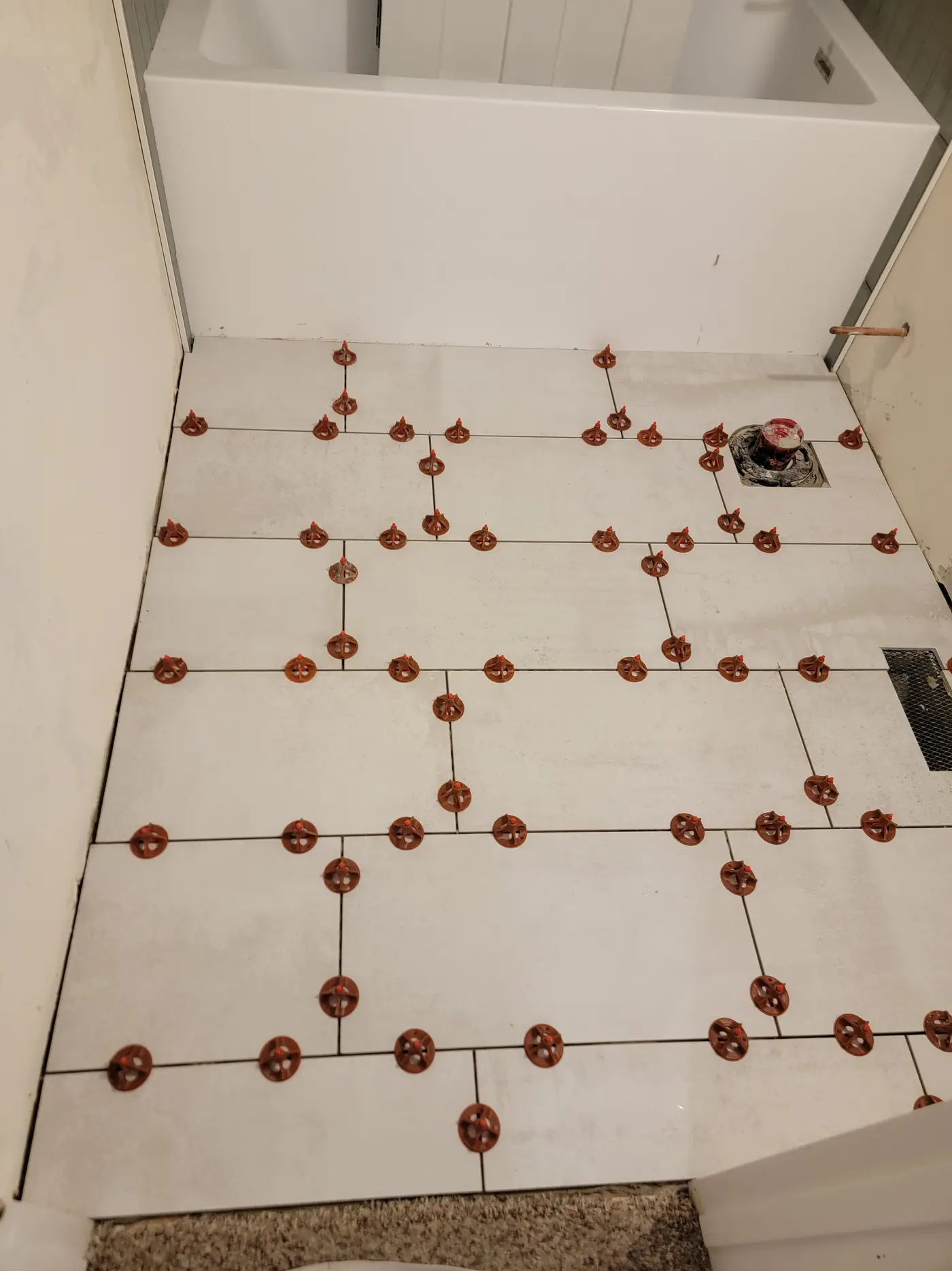 Floor tile, levelling clips in
